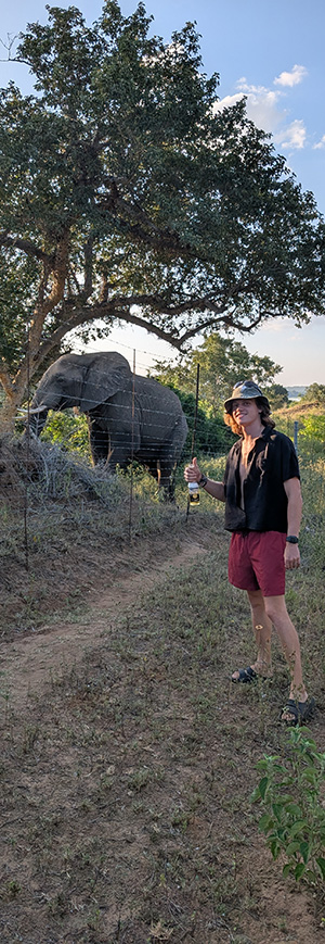 Rene with Elephant right behind him at the fence line