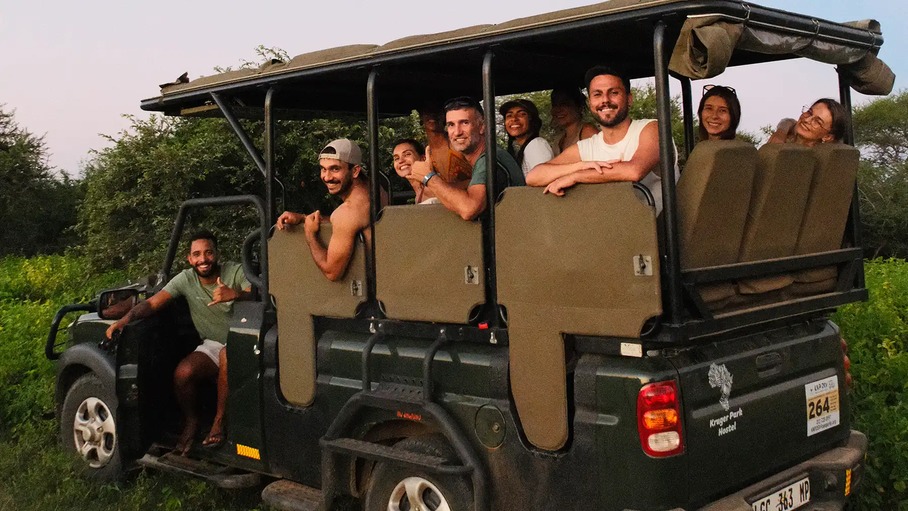 Guests smiling in an open safari vehicle during a game drive near Kruger National Park